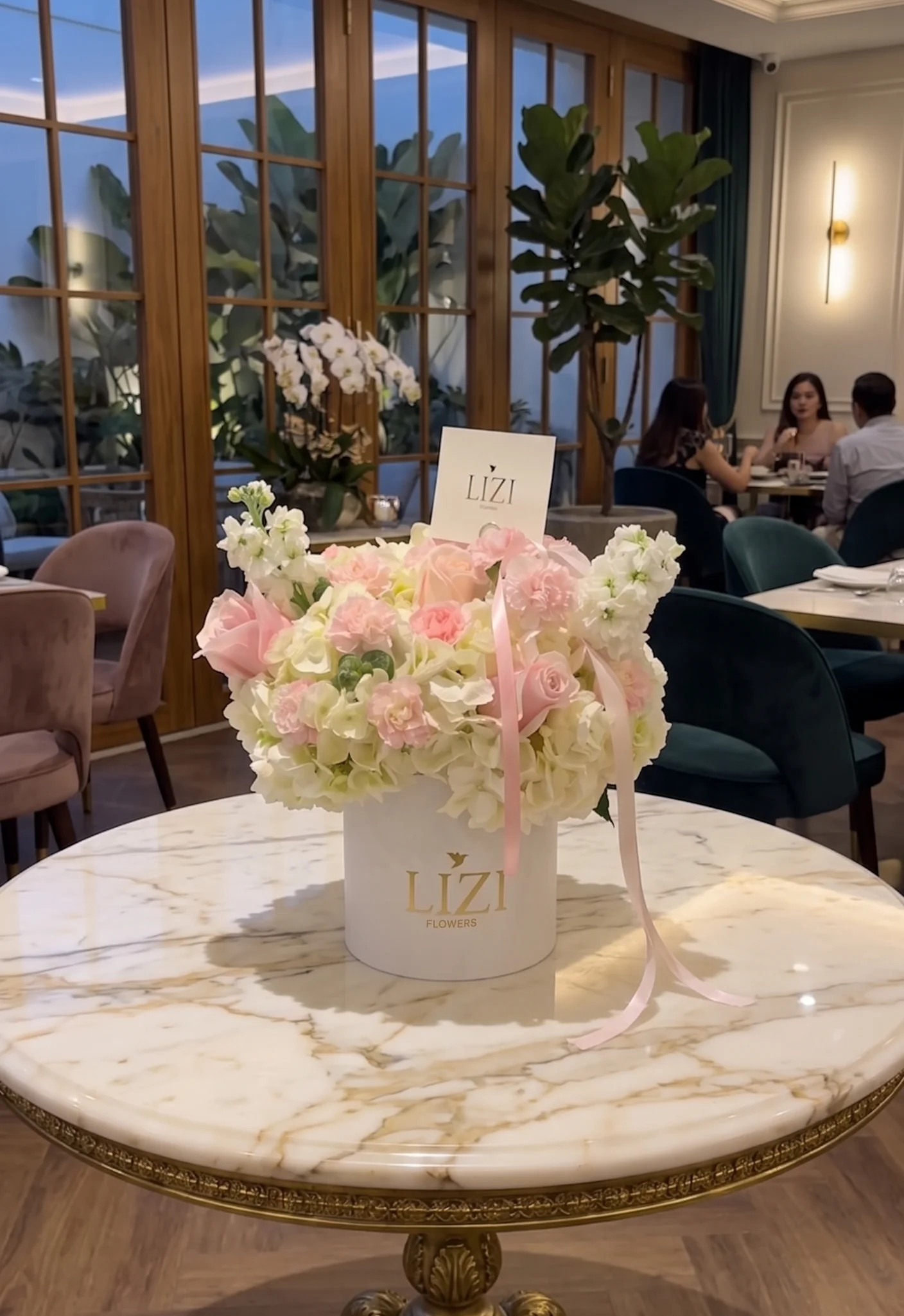 Caja Lizi con hortensias, rosas y flores pastel sobre una mesa de mármol