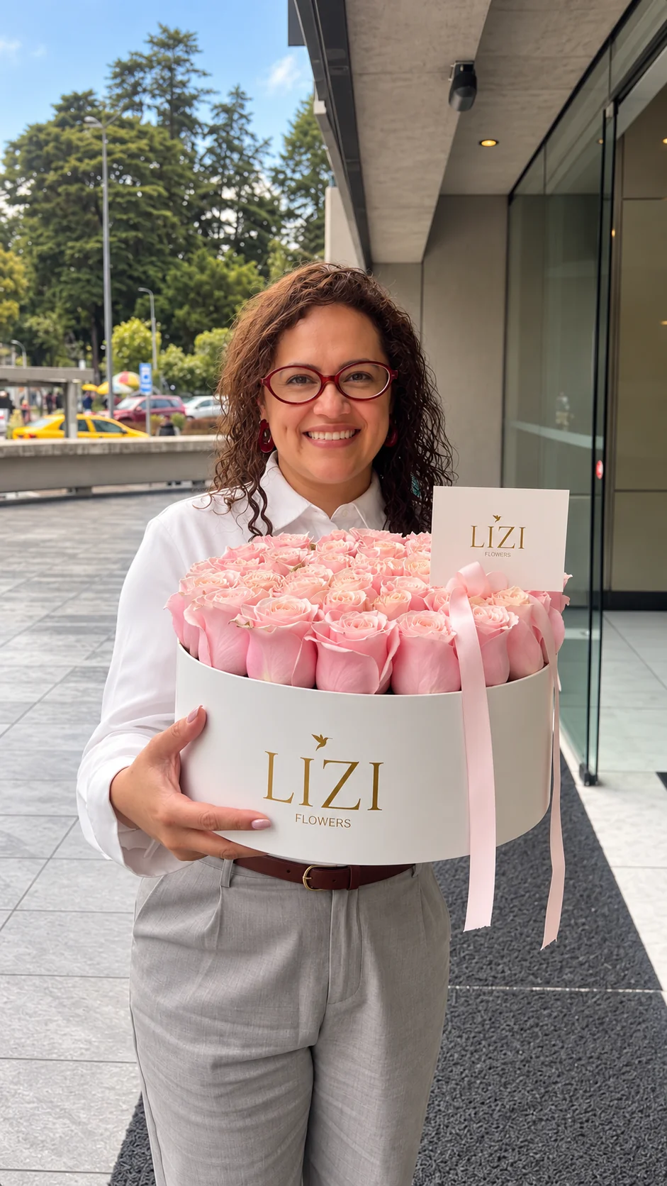 Clienta con un box de rosas rosadas y tarjeta Lizi