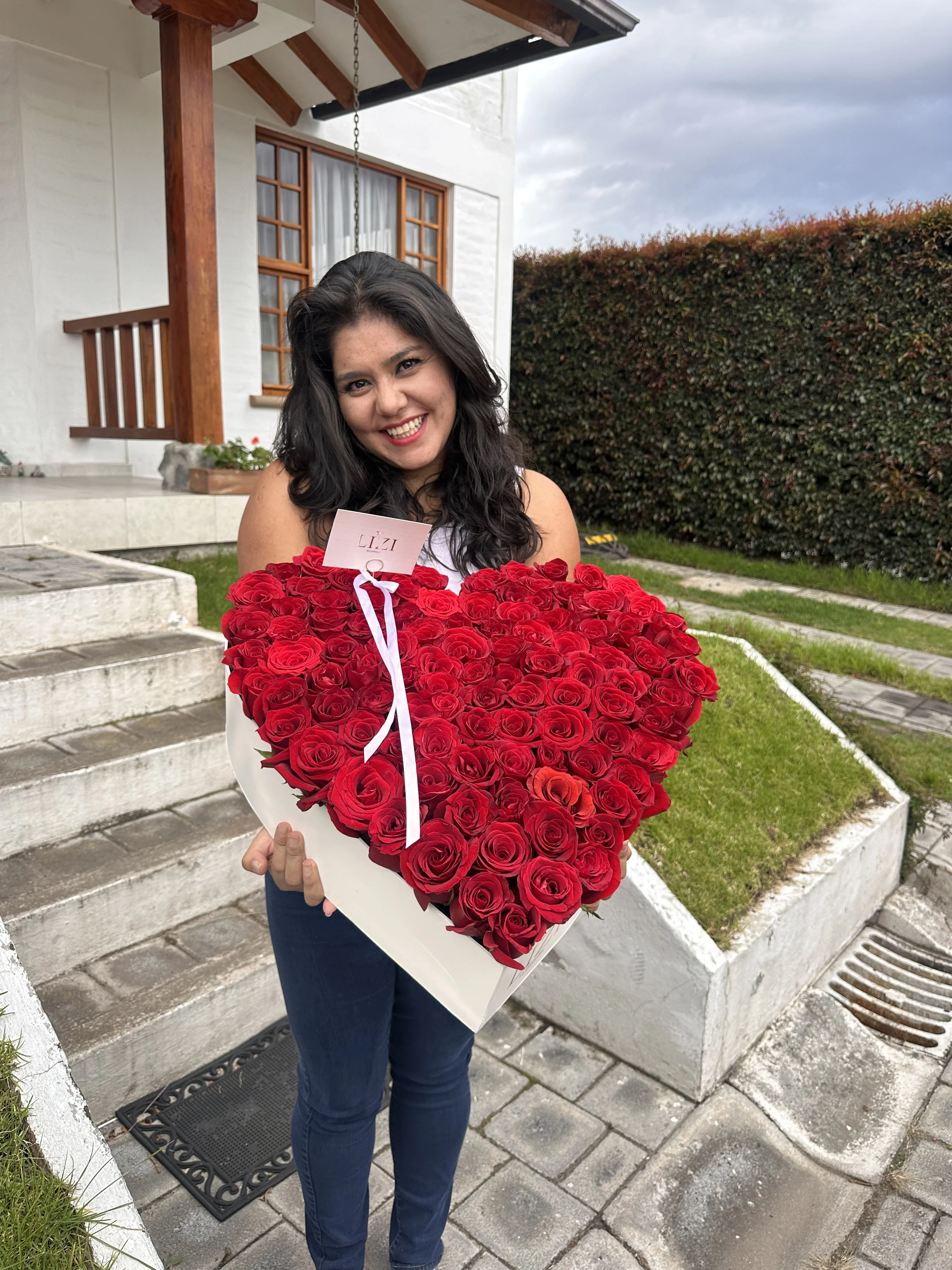 Clienta con un bouquet de rosas rojas al aire libre