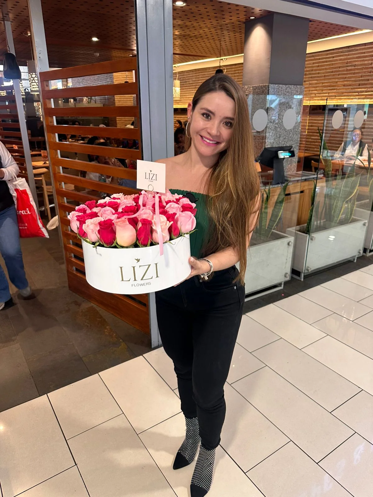 Clienta con un box de rosas rojas y blancas