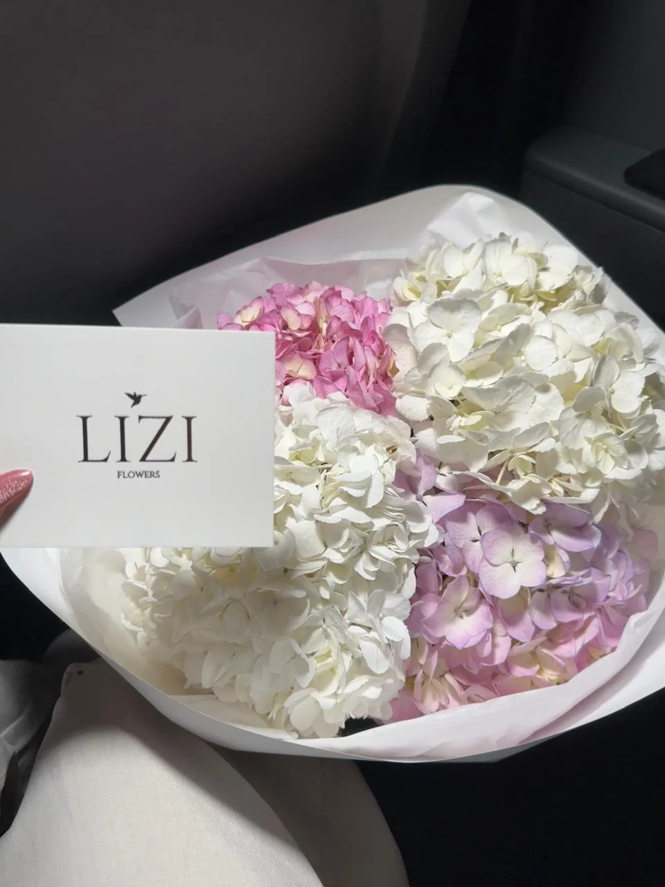 Detalle de un bouquet de hortensias blancas y rosadas con tarjeta Lizi